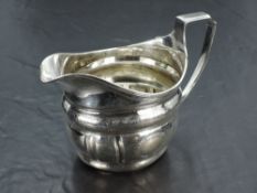A George III silver cream jug, of helmet form with reeded rim and moulded body with bands of