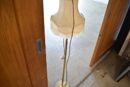 A brass standard lamp with shade
