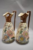 A pair of Victorian water jugs mirrored decoration in the aesthetic style