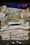 A box full of mixed vintage and retro table linen.