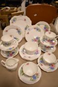 A selection of cheerful bone china cups and saucers, plates and sugar basin, having blue and pink
