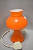 A mid century mushroom style lamp in orange and white inner glass