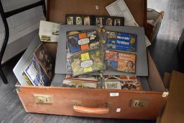 A suitcase containing an assortment of Brooke bond albums, various interests to include flowers,