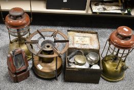 Two vintage paraffin lamps, an early Primus stove with brass reservoir and a similar one in tin box,