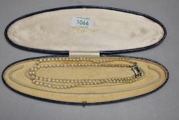 A boxed double string of pearls with decorative clasp