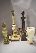Two traditional styled onyx table lamps and a vase sold alongside a metal example.