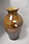 A substantial studio pottery lamp base having mottled brown glaze.