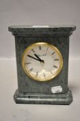 A modern green marble mantel clock having Roman numerals to brass framed face 'Churchill Quartz'.