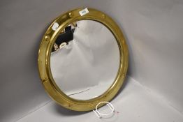A 20th century wall mirror in the form of a port hole having bulls eye glass