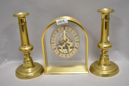 A pair of telescopic candle sticks with a modern brass cased skeleton clock