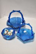 The pieces of blue art glass to include two textured baskets and a heavy ash tray.