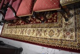 A modern carpet square/rug in burgundy and gold tones