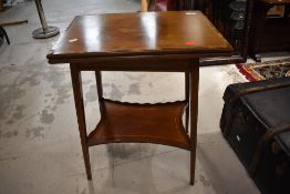 An Edwardian mahogany fold over occasional table