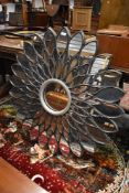 A large composite wall mirror, of floral form, width approx 100cm
