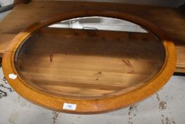 An early to mid 20th Century golden oak oval wall mirror