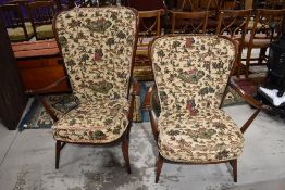 A pair of dark stained Ercol easy armchairs