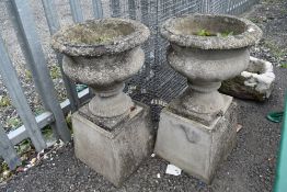 A pair of concrete raised urn planters
