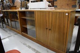 Two mid century book cases in Sapele having glazed doors and one with cupboard storage