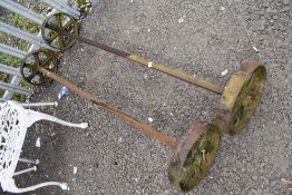 A pair of vintage cast axles and wheels