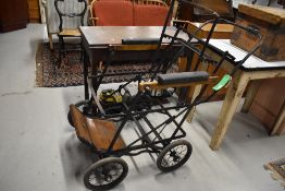 An Edwardian invalid carriage or wheel chair metal frame with rubber wheels