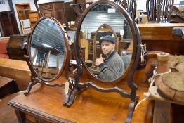 A Regency design toilet or dressing table mirror having mercury glass in mahogany frame with a