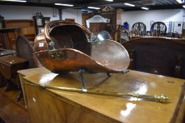 A Victorian copper coal bucket having wrought iron legs with poker