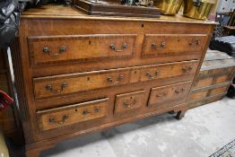 A 19th Century oak kist having mahogany crossbanded decoration, dummy top drawers, long centre and