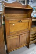 A 19th Century golden oak bureau of shallow proportions with bookshelf over and double cupboard