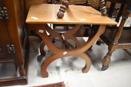 A vintage teak occasional table having stylised frame