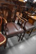 A pair of Victorian carver dining chairs having fret work back with carved mahogany frames