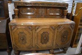 An Edwardian side board or cocktail cabinet with carved oak cupboard doors