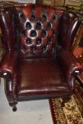 A traditional leather wing back chair