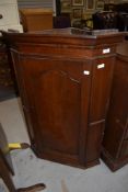 A Victorian oak cased corner cupboard having shelved interior