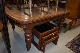 An Edwardian heavy set oak dining table extending with one leaf