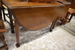 An early 20th Century mahogany drop leaf dining table having ball and claw feet