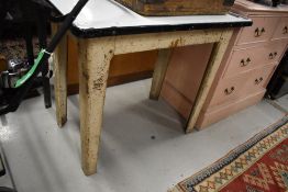 An early 20th century utility table with metal frame and enamel table top