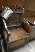An 17th century oak framed Monks chair with storage having carved back and initials TWM, comes