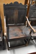 An 18th century Monks style chair having oak frame with shaped and plank back