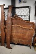 A late Victorian bed frame in oak having typical French design with carved legs and foliate