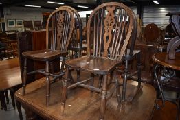 A set of four 20th century hoop and wheel back beech wood dining chairs