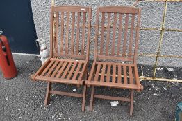 A pair of teak folding garden chairs
