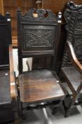An 18th century refectory chair in oak having carved sunflower back