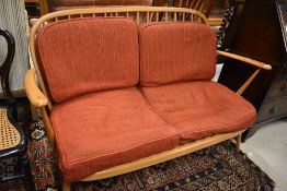 A mid century Ercol two seater couch or sofa having blue badge