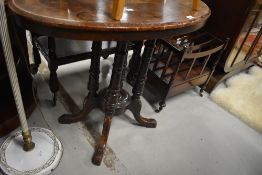 A Victorian mahogany and inlaid oval occasional table having quadruple turned column supports and