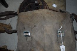 A canvas bag of vintage reels and fishing tackle