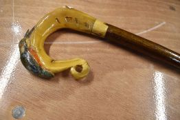 A walking stick with Kingfisher carved into handle