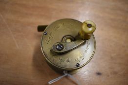 A small brass fly fishing reel marked Ustonson Maker to the Queen, Temple Bar London 2.25 inch