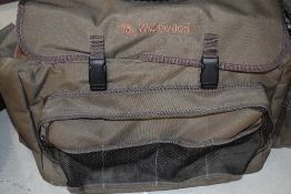 A Wychwood fishing bag containing two vintage reels and several copies of trout and salmon magazines
