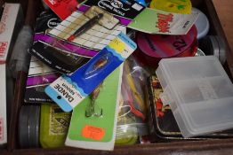 A wooden box containing a quantity of vintage minnows and lures