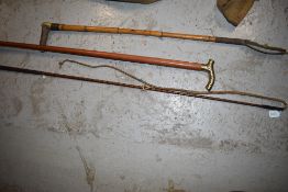 Two whips and a brass handled walking stick